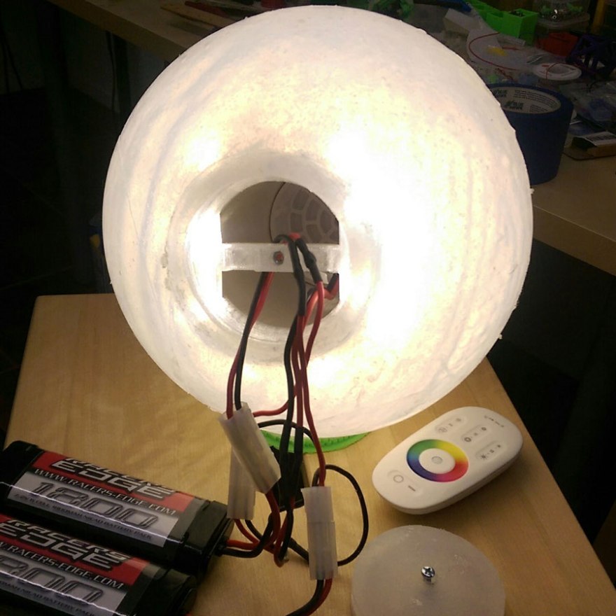 Completed ball with open battery port, batteries and remote